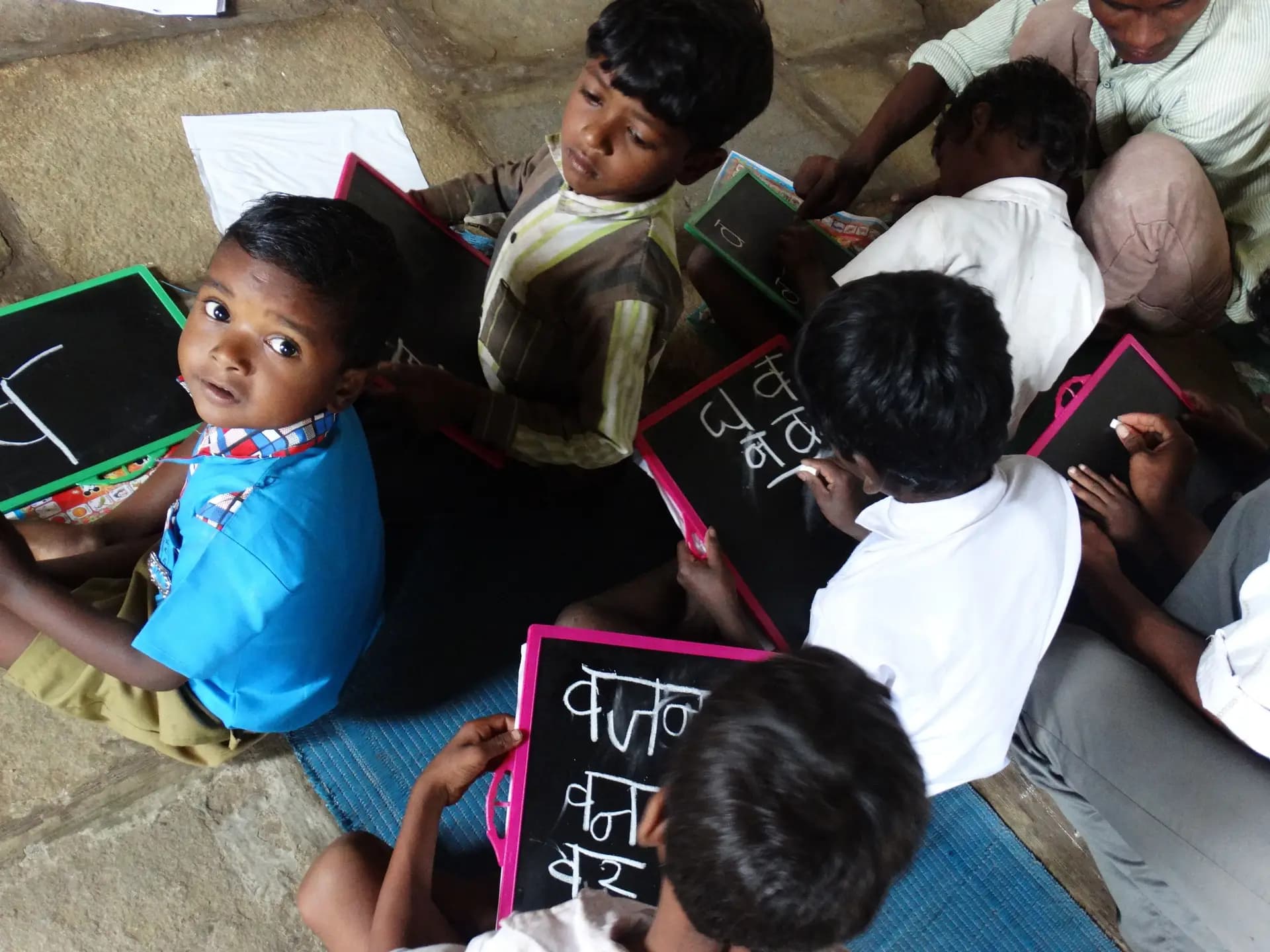 Children writing on slates during a lesson