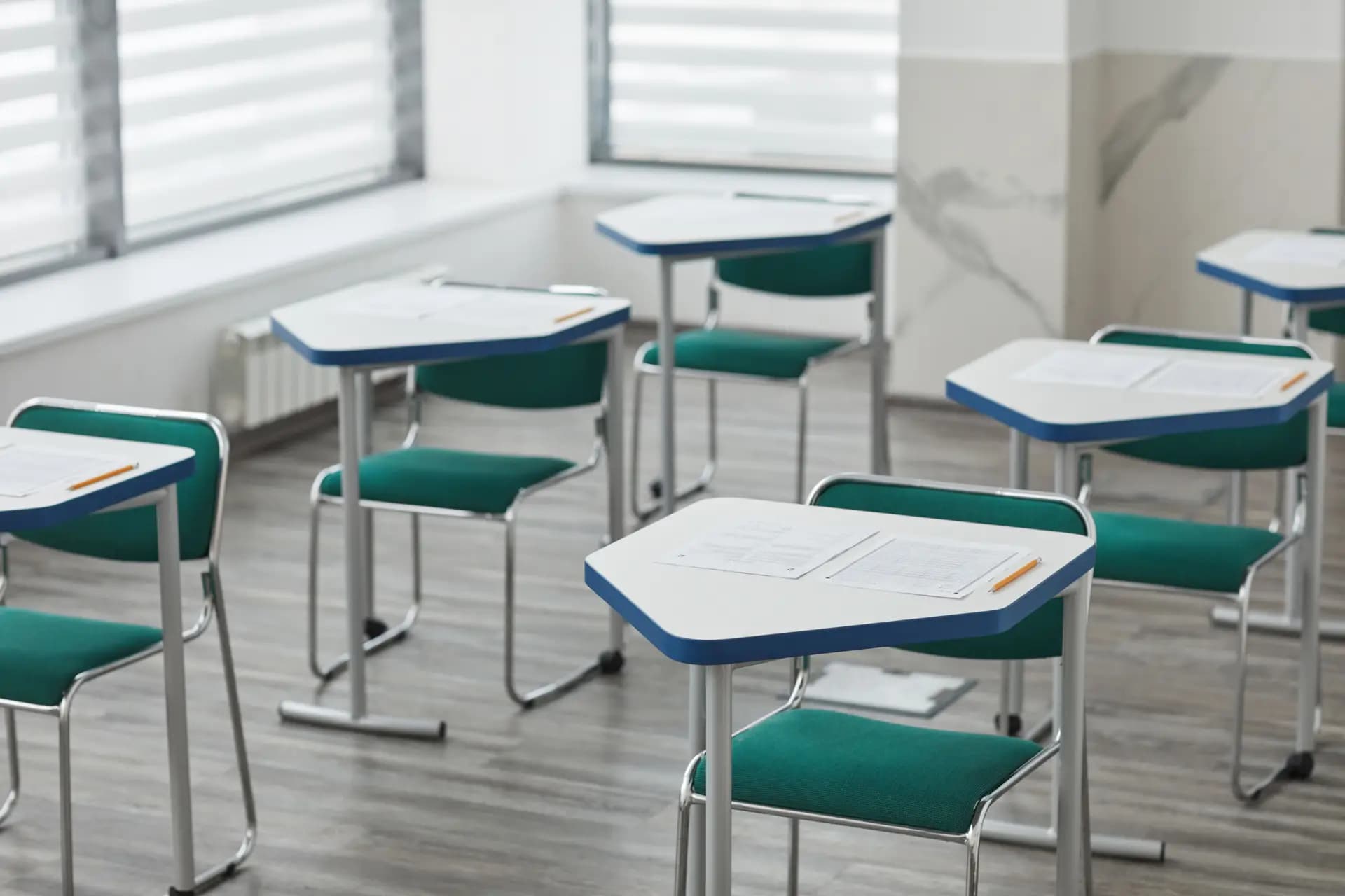 Students seated at desks in a large school hall